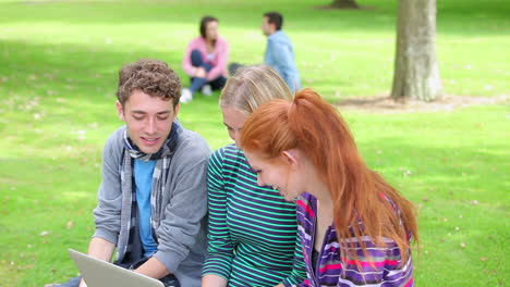 Three-students-looking-at-the-laptop-together-and-laughing