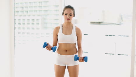 Fit-young-woman-lifting-dumbbells-and-laughing