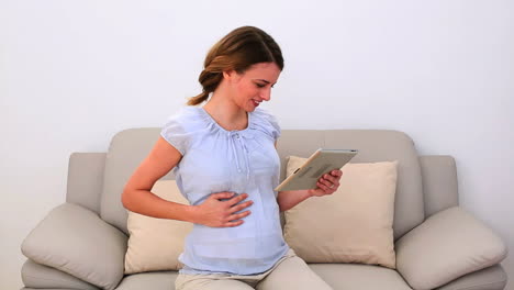 Schwangere-Frau-Mit-Ihrem-Tablet-PC-Auf-Der-Couch