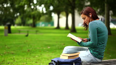 Hübsche-Studentin-Sitzt-Auf-Der-Bank-Und-Liest-Ein-Buch