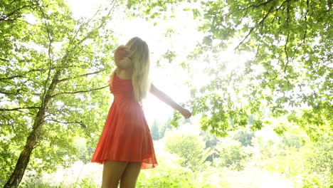 Beautiful-teen-twirling-in-the-sunlight-under-the-trees