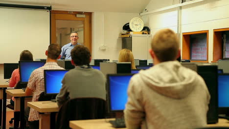 Estudiantes-Escuchando-Al-Profesor-En-La-Sala-De-Computadoras