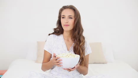 Junge-Frau-Isst-Eine-Schüssel-Popcorn-Auf-Dem-Bett