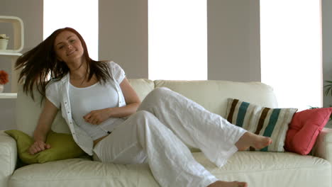 Young-woman-sitting-down-on-her-couch