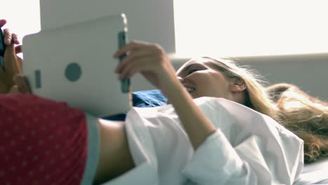 Pretty-model-using-tablet-while-lying-on-bed