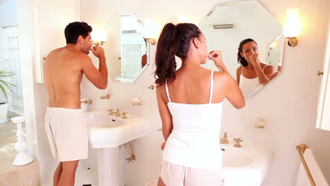 Attractive-couple-brushing-their-teeth-in-the-morning