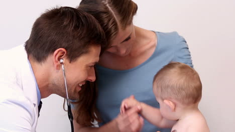 Bonita-Madre-Sosteniendo-A-Su-Bebé-Mientras-El-Pediatra-Escucha-Su-Pecho.