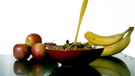 Orange-juice-pouring-into-bowl-of-cereal