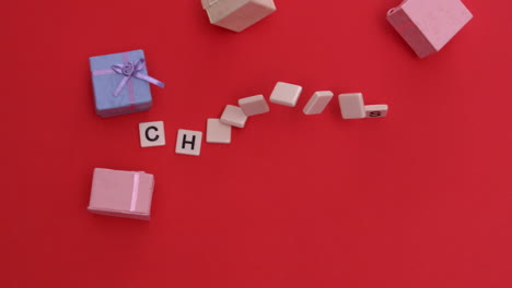 Weiße-Buchstabensteine,-Die-Sich-Bewegen,-Um-Weihnachten-Mit-Geschenken-Zu-Buchstabieren