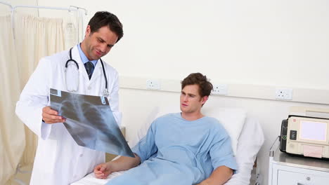 Doctor-showing-patient-in-bed-an-xray