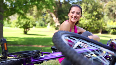 Fit-girl-taking-off-her-bike-helmet-smiling-at-camera