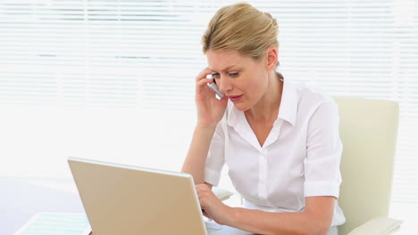 Mujer-De-Negocios-Trabajando-En-Una-Computadora-Portátil-Mientras-Habla-Por-Teléfono