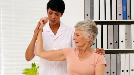 Krankenschwester-Zeigt-Einer-älteren-Patientin,-Wie-Sie-Ihren-Verletzten-Arm-Trainiert