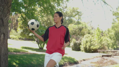 Asian-girl-playing-football-in-the-park