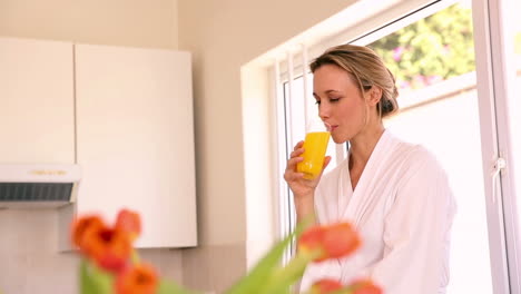 Happy-woman-drinking-orange-juice-in-the-morning-