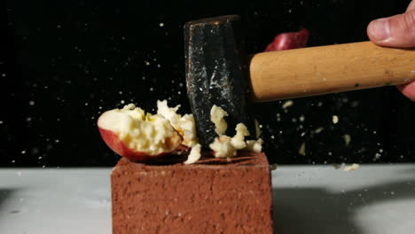 Hammer-smashing-apple-over-bricks