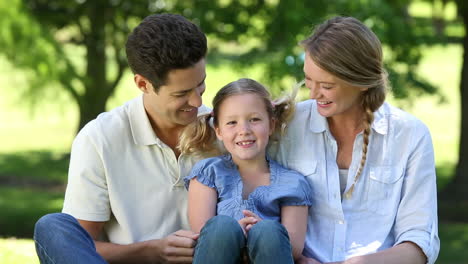 Happy-parents-with-their-young-daughter-in-the-park