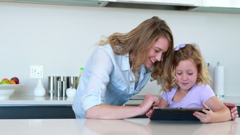 Little-girl-using-a-digital-tablet-with-her-mother