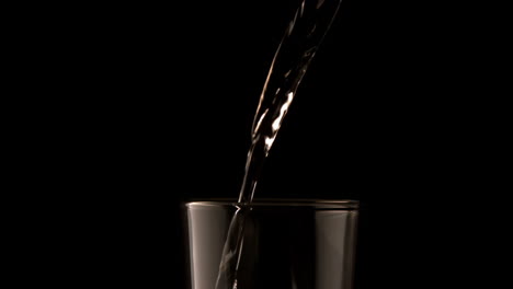 Agua-Vertida-En-Vaso-Sobre-Fondo-Negro