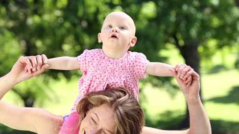 Happy-mother-playing-with-her-baby-girl-in-the-park