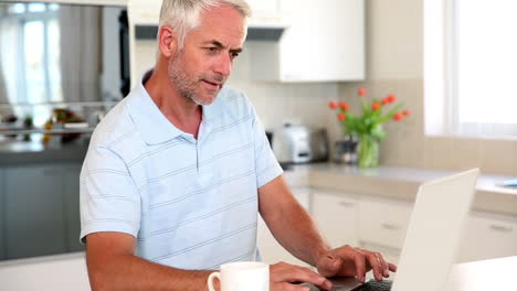 Hombre-Casual-Usando-Una-Computadora-Portátil-En-El-Mostrador