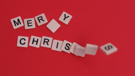Buchstabensteine,-Die-Bewegt-Werden,-Um-Frohe-Weihnachten-Auf-Rotem-Hintergrund-Zu-Buchstabieren