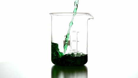 Green-liquid-pouring-into-beaker