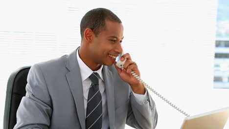 Businessman-talking-on-the-phone-at-his-desk
