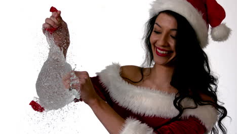 Pretty-brunette-in-santa-outfit-popping-a-water-balloon