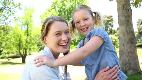 Glückliches-Kleines-Mädchen-Erzählt-Ihrer-Mutter-Ein-Geheimnis-Im-Park