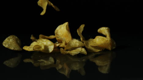 Chips-Fallen-Auf-Schwarze-Oberfläche