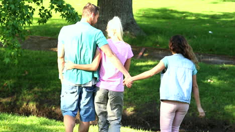 Boy-holding-hands-with-another-girl-behind-his-girlfriends-back