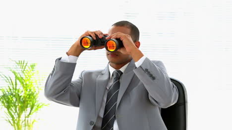 Curious-businessman-looking-through-binoculars-