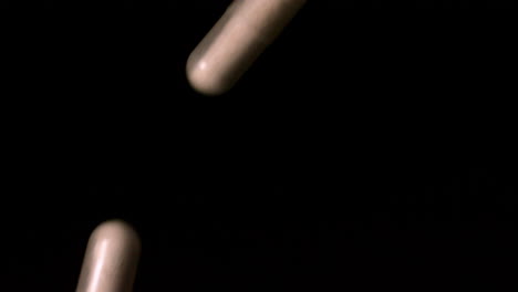 Pill-capsules-pouring-on-black-background