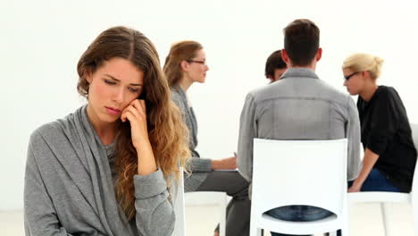 Rehab-group-sitting-in-a-circle-with-one-woman-excluded