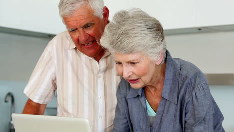 Senior-couple-using-the-laptop-at-the-counter