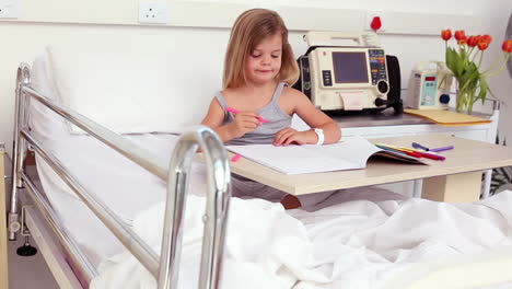 Little-girl-sitting-in-hospital-bed-colouring