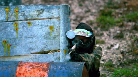 Man-shooting-his-paintball-gun-hiding-behind-fence