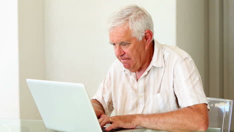 Senior-man-using-laptop-at-the-table
