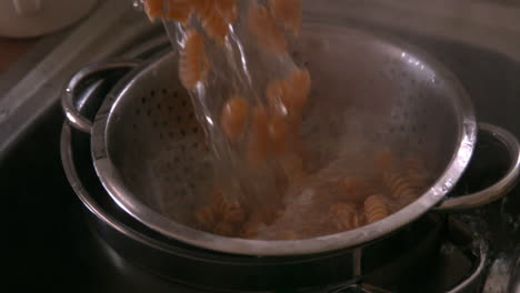 Pasta-being-poured-into-a-colander