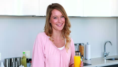 Pretty-woman-standing-with-glass-of-orange-juice