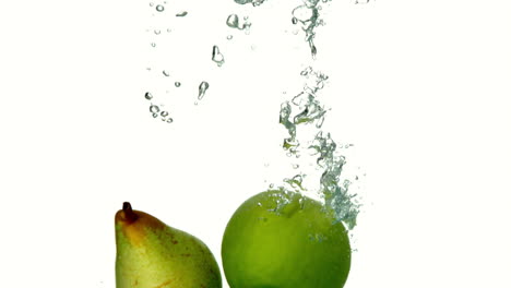 Pera-Y-Manzana-Sumergiéndose-En-Agua-Sobre-Fondo-Blanco.