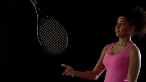 Fit-woman-in-pink-tossing-a-tennis-racket