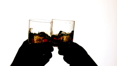 Silhouette-of-hands-clinking-whiskey-glasses