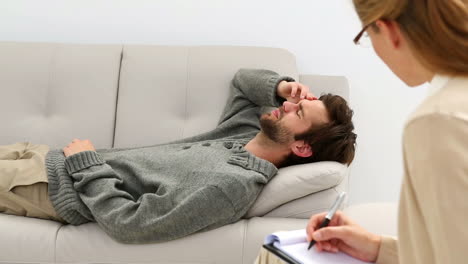 Young-man-lying-on-sofa-talking-to-his-therapist