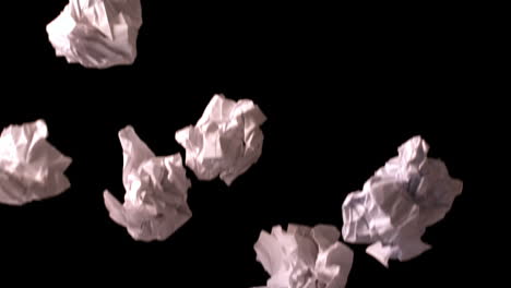 Crumpled-paper-falling-against-black-background