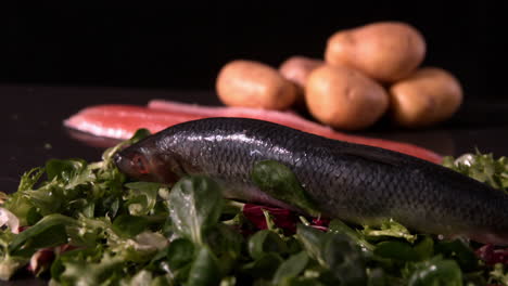 Fresh-whole-trout-falling-on-a-bed-of-leaves