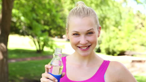 Fit-blonde-drinking-water-in-the-park