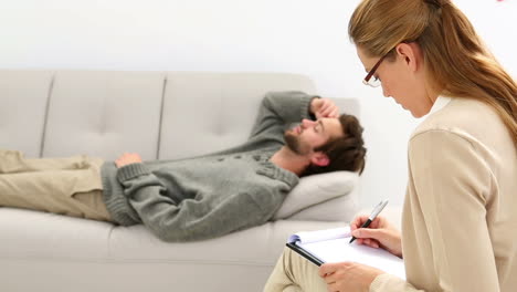 Young-man-lying-on-sofa-talking-to-his-therapist