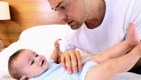 Padre-Feliz-Haciéndole-Cosquillas-A-Su-Hijo-En-La-Cama